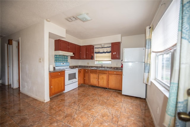 kitchen with sink, white appliances, and a textured ceiling