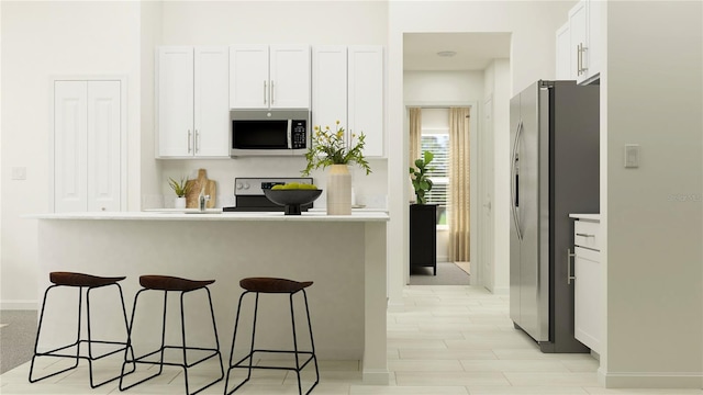 kitchen with white cabinetry, stainless steel appliances, and a breakfast bar