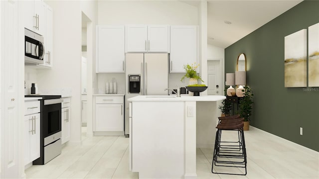 kitchen with white cabinetry, stainless steel appliances, a kitchen breakfast bar, a center island with sink, and vaulted ceiling