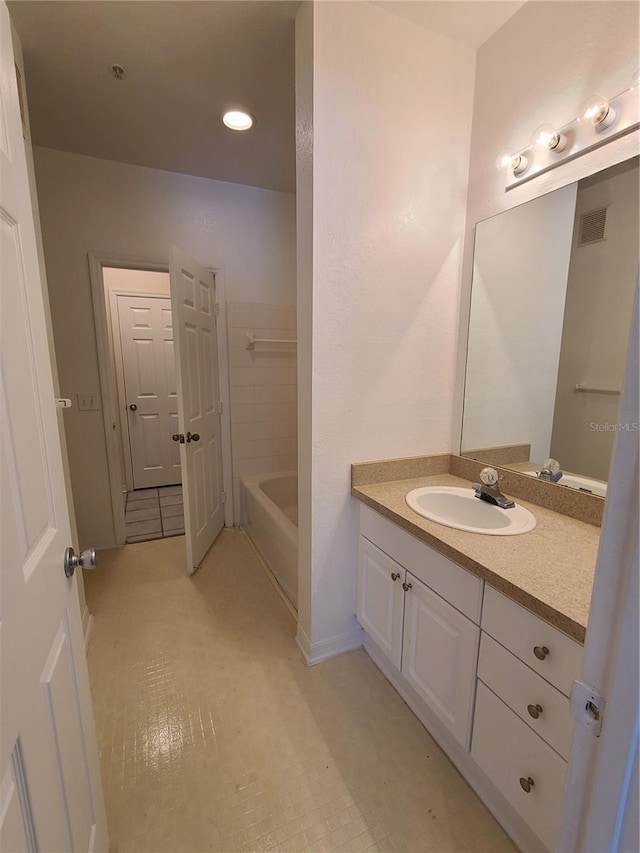 bathroom featuring tile patterned floors, vanity, and a tub