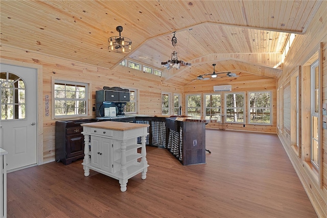 kitchen featuring vaulted ceiling, dark brown cabinets, wood ceiling, and wood walls