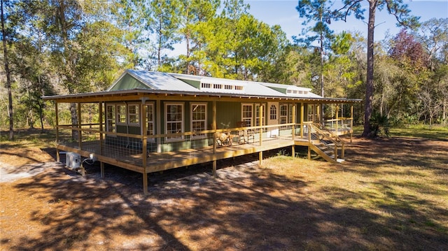 rear view of house with a sunroom and a deck