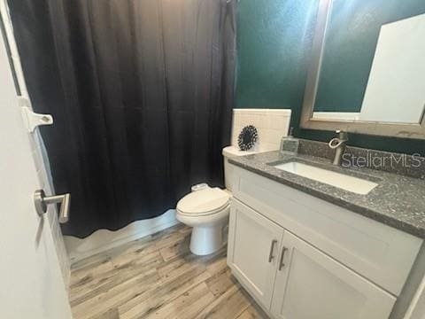 bathroom featuring vanity, wood-type flooring, and toilet