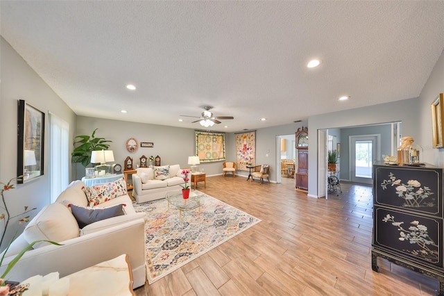 living room with ceiling fan and a textured ceiling