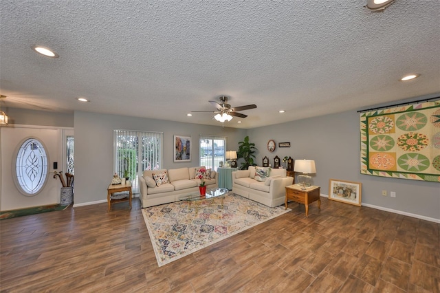 living room with dark hardwood / wood-style flooring, ceiling fan, and a textured ceiling