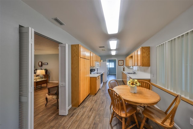 kitchen featuring sink, white appliances, and hardwood / wood-style flooring