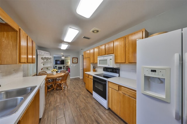 kitchen with sink, decorative backsplash, ceiling fan, dark wood-type flooring, and white appliances