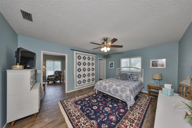 bedroom with ceiling fan, dark hardwood / wood-style floors, and multiple windows