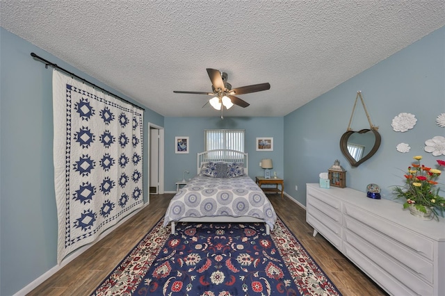 bedroom featuring dark wood-type flooring, ceiling fan, and a textured ceiling