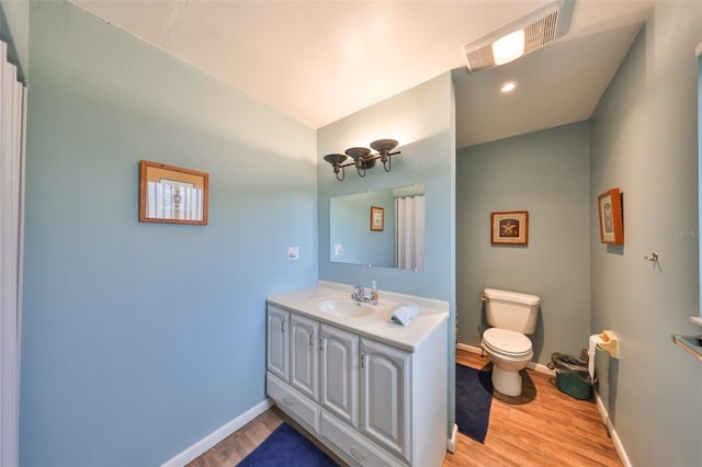 bathroom featuring vanity, wood-type flooring, and toilet