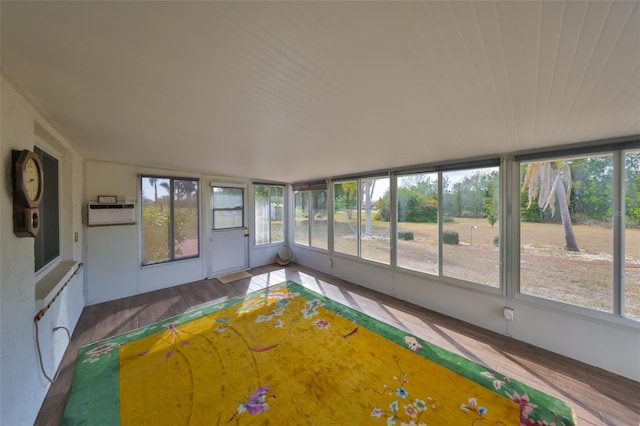 unfurnished sunroom featuring a healthy amount of sunlight and a wall mounted AC