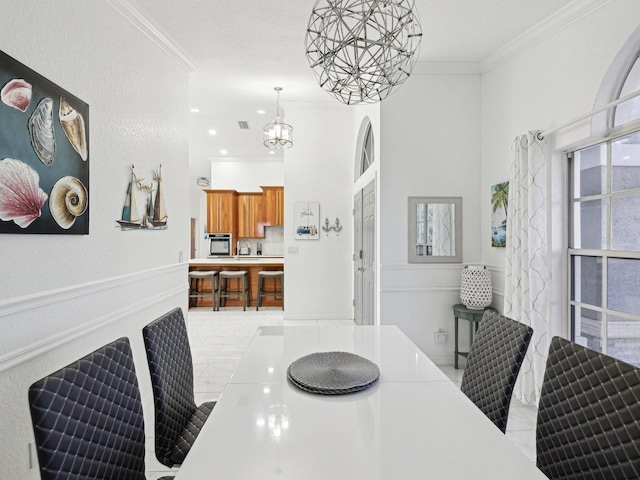 dining area featuring ornamental molding and an inviting chandelier