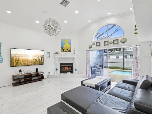 living room featuring a towering ceiling, ornamental molding, and a premium fireplace