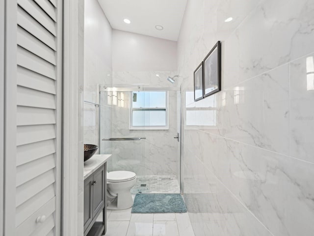 bathroom with vanity, toilet, and tiled shower