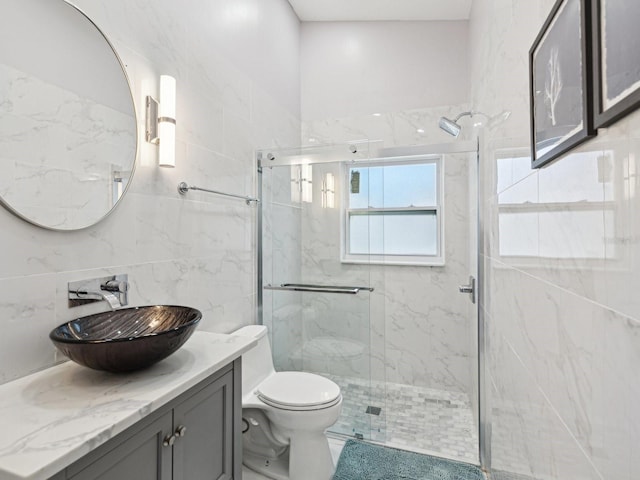 bathroom featuring tile walls, decorative backsplash, vanity, walk in shower, and toilet