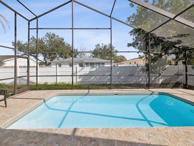 view of pool with a patio area and glass enclosure