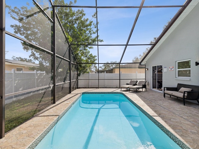 view of swimming pool with a patio, an outdoor hangout area, and glass enclosure