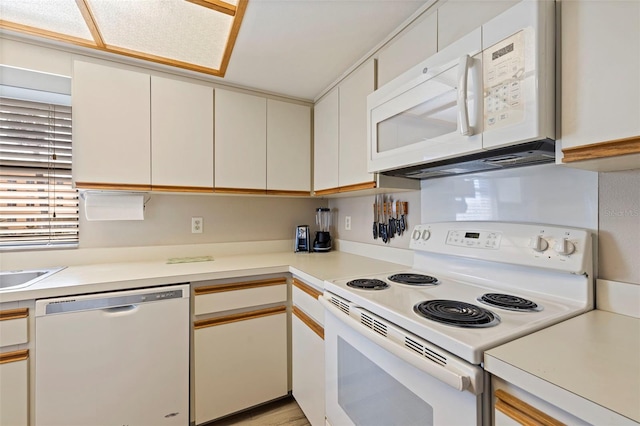 kitchen featuring white cabinetry and white appliances