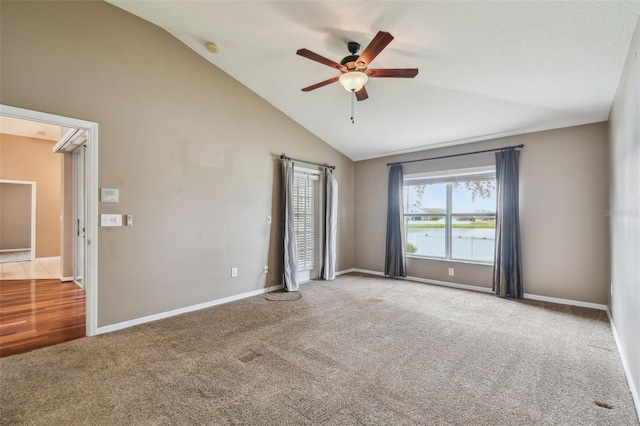 unfurnished bedroom featuring vaulted ceiling, a water view, carpet flooring, and ceiling fan