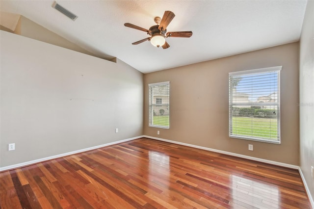 spare room featuring wood-type flooring, lofted ceiling, a textured ceiling, and ceiling fan