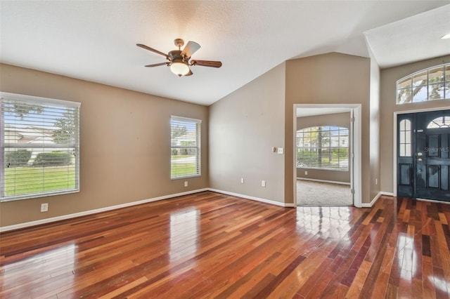 foyer entrance with lofted ceiling, dark hardwood / wood-style floors, and ceiling fan