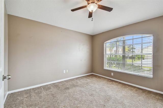 spare room with ceiling fan and light colored carpet