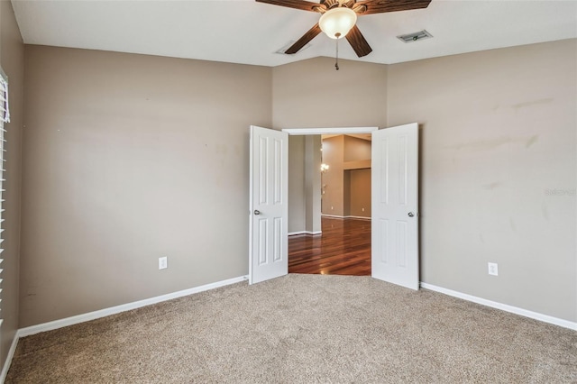 empty room with ceiling fan and dark carpet