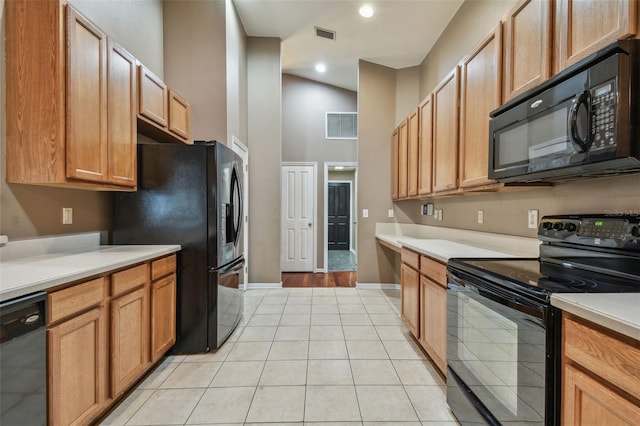 kitchen with high vaulted ceiling, light tile patterned floors, and black appliances