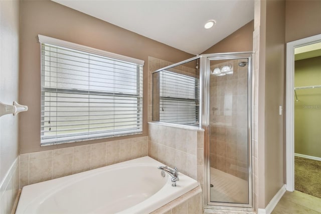 bathroom featuring independent shower and bath, lofted ceiling, and a wealth of natural light