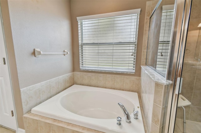 bathroom featuring shower with separate bathtub