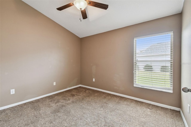 empty room featuring lofted ceiling, ceiling fan, and carpet