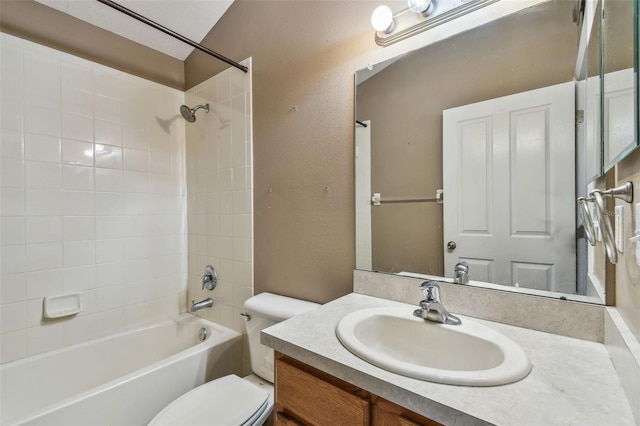 full bathroom with tiled shower / bath, vanity, and toilet