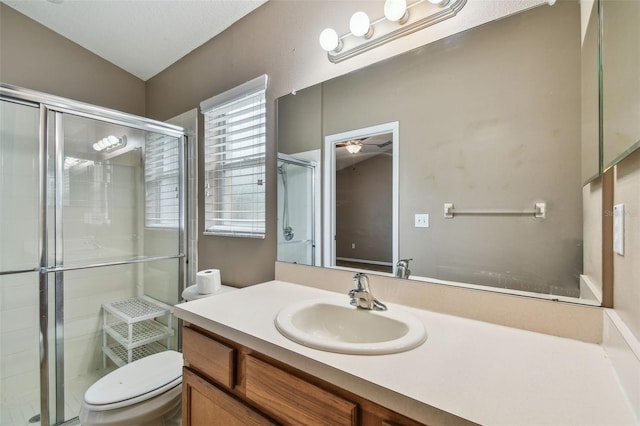 bathroom featuring vanity, a shower with shower door, toilet, and vaulted ceiling