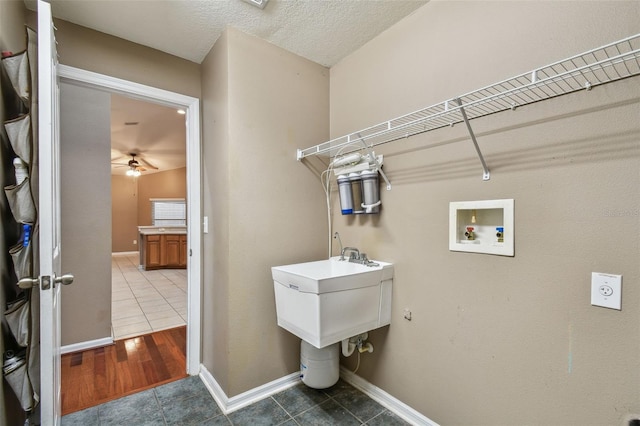 laundry area with washer hookup, ceiling fan, tile patterned floors, and a textured ceiling