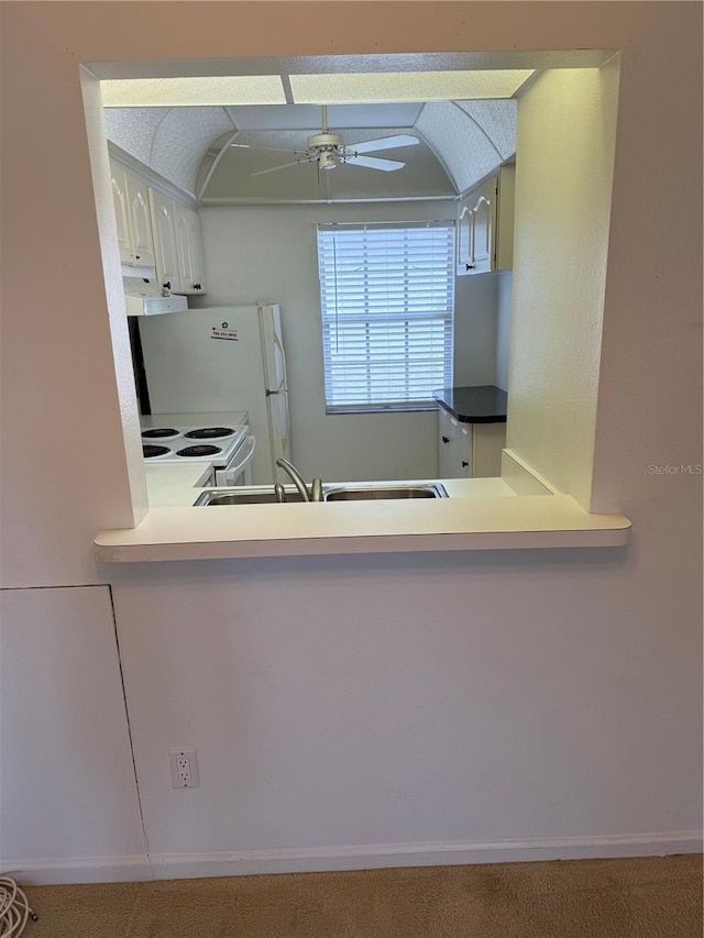 kitchen with ceiling fan, a sink, white appliances, under cabinet range hood, and vaulted ceiling