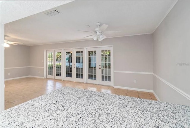 tiled spare room with ornamental molding, ceiling fan, and french doors