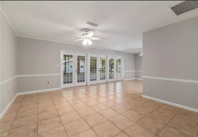 unfurnished room featuring light tile patterned flooring, ornamental molding, ceiling fan, a textured ceiling, and french doors