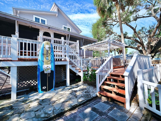 back of house with a pergola and a deck