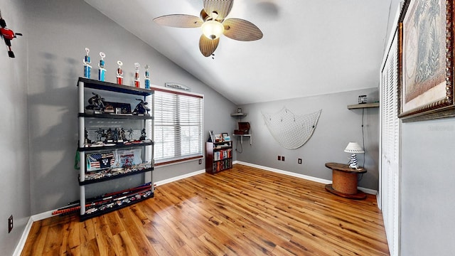 interior space with ceiling fan, vaulted ceiling, and wood-type flooring