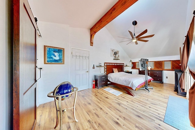 bedroom featuring vaulted ceiling with beams, ceiling fan, a barn door, and light wood-type flooring