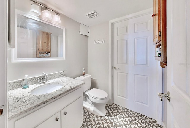 bathroom with vanity, tile patterned floors, and toilet