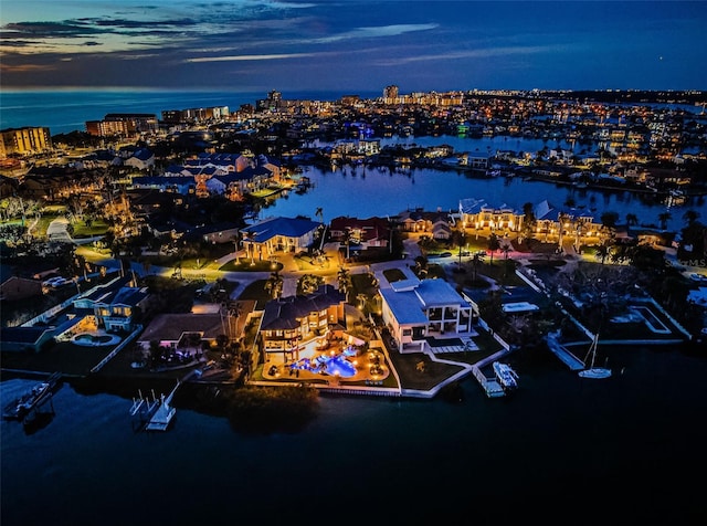 aerial view at dusk featuring a water view