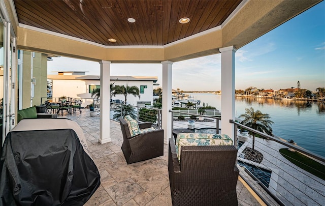 exterior space with a balcony, a water view, and grilling area