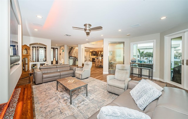 living room with light hardwood / wood-style floors and ceiling fan