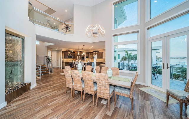 dining room featuring a high ceiling, hardwood / wood-style floors, and french doors