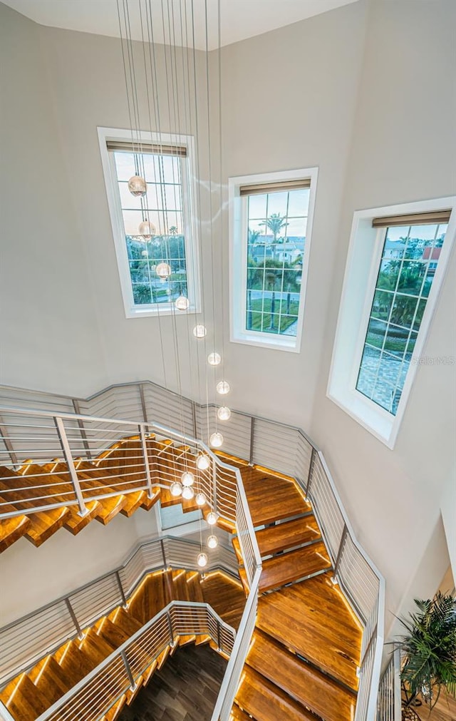 stairway featuring a towering ceiling