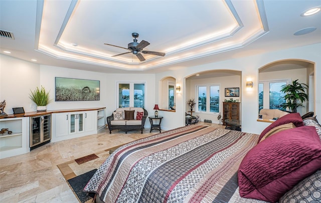 bedroom featuring a raised ceiling and beverage cooler