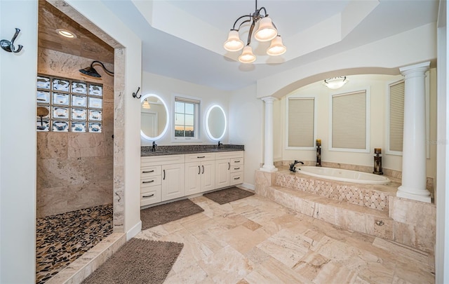 bathroom featuring decorative columns, a raised ceiling, vanity, and plus walk in shower