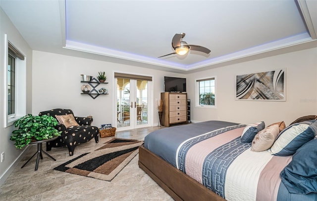 bedroom with a raised ceiling, ceiling fan, and french doors