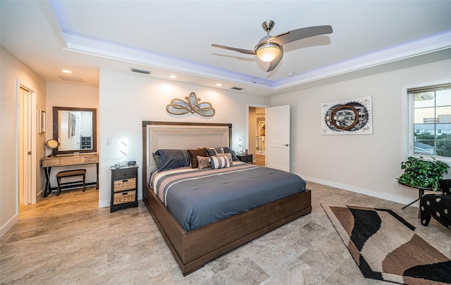 bedroom featuring ceiling fan and a tray ceiling